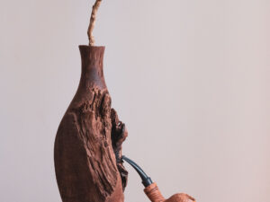 Tomato pipe made of sandblasted olive wood. Still life photo.