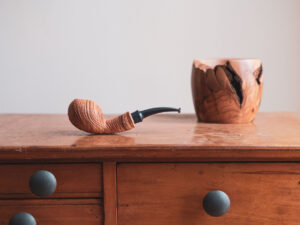 Tomato pipe made of sandblasted olive wood. Still life photo.