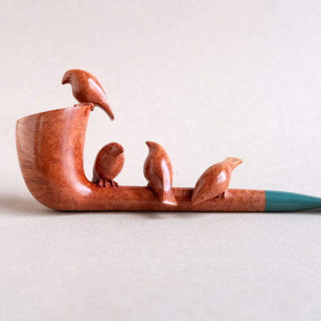 A sculptural smoking pipe handmade of briar, with tiny birds sculpted on it.